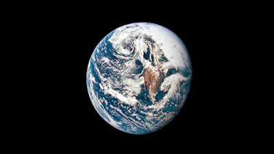 Earth viewed from space showing blue oceans, white clouds, and continental landmasses against black background