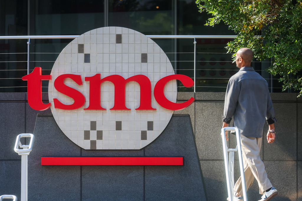 TSMC logo displayed on building exterior signage with person walking past