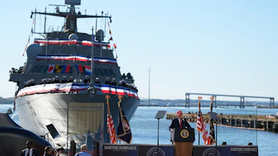 USCGC Maritime Dominance naval vessel at commissioning ceremony with officials and American flags at waterfront dock