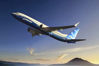 Boeing 737 aircraft in flight over mountainous landscape at sunset
