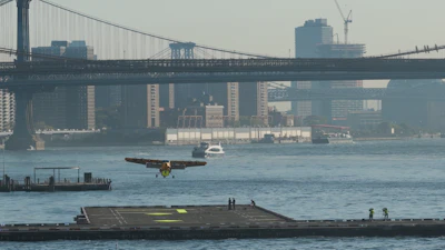Seaplane landing on East River near Manhattan Bridge with NYC skyline in background
