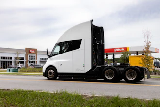 White semi-truck parked at Plas fuel station with open sleeper cab door