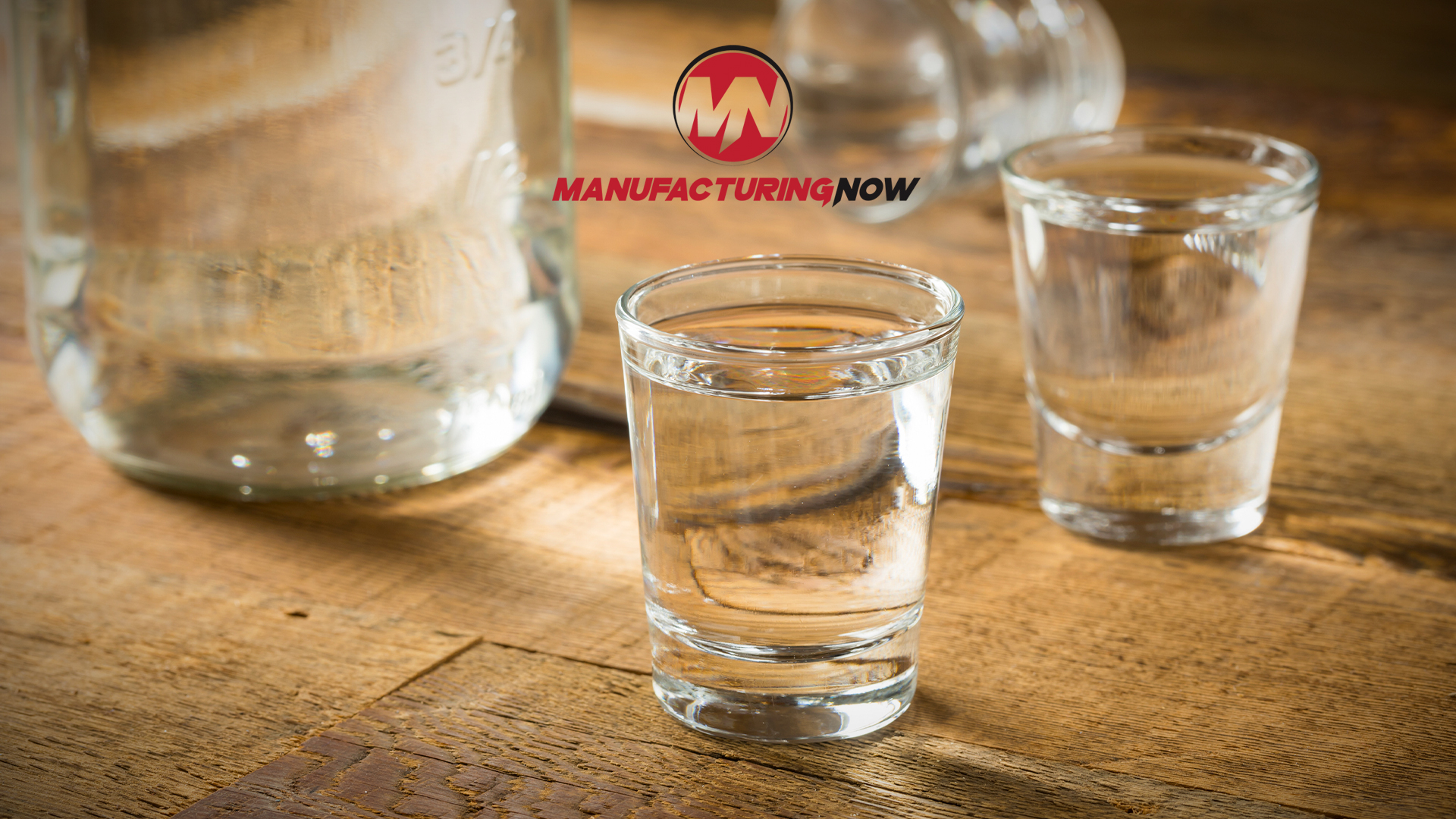 ManufacturingNow logo with glasses of water on wooden surface