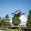 Police drone in flight over Florida Poly campus with trees and modern architecture in background