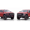 Two red lifted pickup trucks with custom front bumpers and roof lights displayed side by side