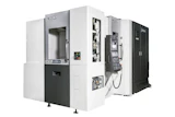 OKUMA CNC machining center with white and black exterior, doors open showing internal mechanical components and control panels