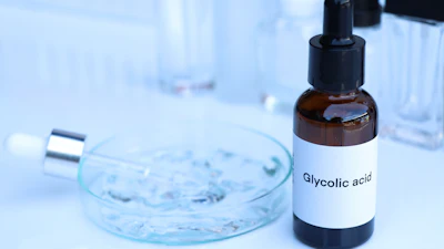 Glycolic acid bottle with dropper in laboratory setting with petri dish and test tubes