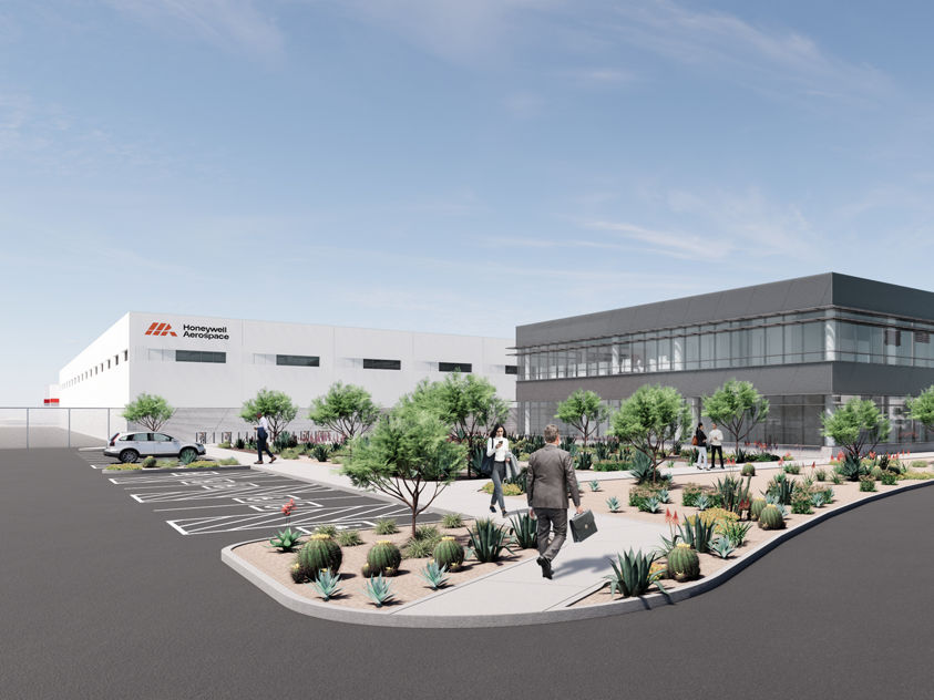 Architectural rendering of modern office and industrial facility with white and gray buildings, desert landscaping, parking area, and people in courtyard.