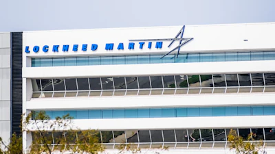 Lockheed Martin logo and text on modern white office building facade with blue glass windows