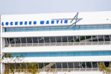 Lockheed Martin logo and text on modern white office building facade with blue glass windows