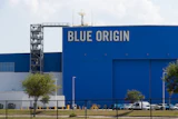 Blue Origin aerospace facility with large blue building facade displaying company name and launch tower