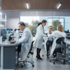 Scientists and technicians working in a modern laboratory with microscopes and analytical equipment