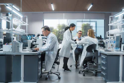 Scientists and technicians working in a modern laboratory with microscopes and analytical equipment
