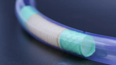 Blue flexible tube with cyan translucent sections showing internal mesh structure against dark background