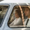 Two people seated in vintage aircraft cabin with sunlight streaming through windows