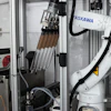 ASKAWA industrial robotic arm with tool changer mounted in manufacturing enclosure