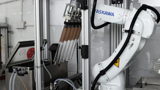 ASKAWA industrial robotic arm with tool changer mounted in manufacturing enclosure