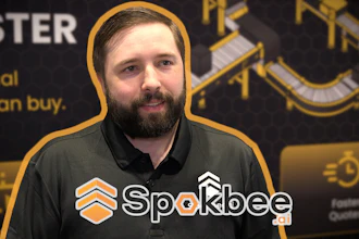 Man wearing Sparkbee branded black polo shirt at promotional event with gold and black backdrop