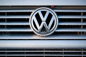 Volkswagen logo on wet vehicle grille with chrome trim